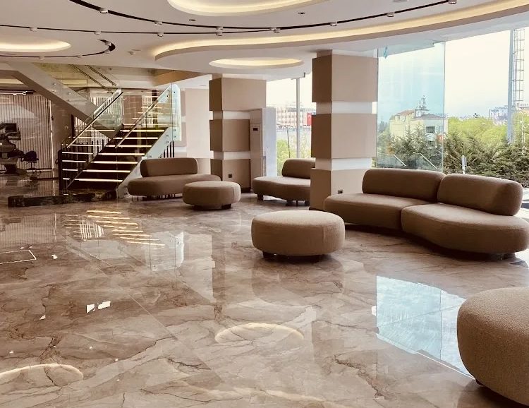 Warm-toned reception area with sofas and a marble floor at the Global Health Hair clinic in Istanbul